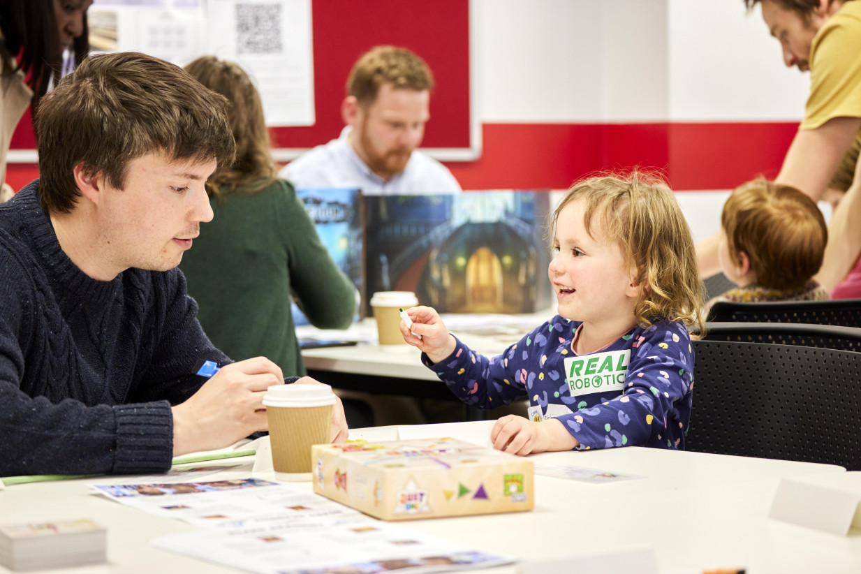 Board reading photograph FoSS - an adult and child playing a game