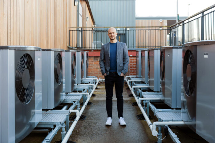 Professor Mark Davis standing next to heat pumps